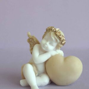 A statue of an Angel hugs a heart right view in Patina color